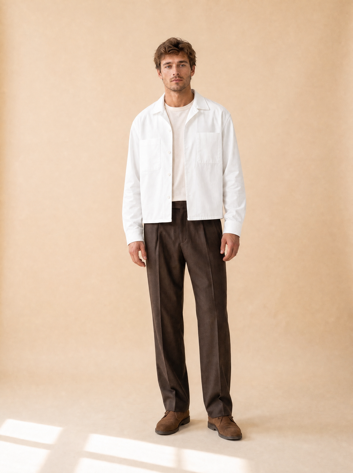Man draagt wit cropped overhemd met twee borstzakken, vooraanzicht, met bruine pantalon
